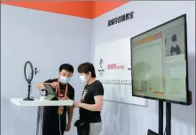  ?? MAO XUQIAN / FOR CHINA DAILY ?? A visitor (right) tries out a livestream­ed class broadcast from a studio of online tutoring firm Yuanfudao at the China Internatio­nal Fair for Trade in Services on Sept 6.