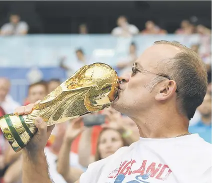  ?? Picture: AFP ?? SIGN OF THINGS TO COME? An England fan kisses a replica of the World Cup during their quarterfin­al against Sweden at the Samara Arena on Saturday.