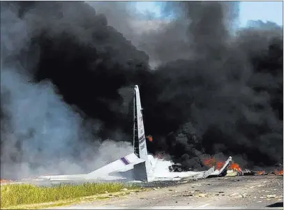  ?? James Lavine ?? The Associated Press Flames and smoke rise from an Air National Guard C-130 cargo plane after it crashed Wednesday near Savannah, Ga.