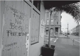  ?? COUNTY DAILY NEWS VIA THE ASSOCIATED PRESS] ?? The Shark Shack Beach Bar and Grill is boarded up on the nearly deserted Strand Street in Galveston as business owners and residents wait for Hurricane Laura on Wednesday. [JENNIFER REYNOLDS/ THE GALVESTON