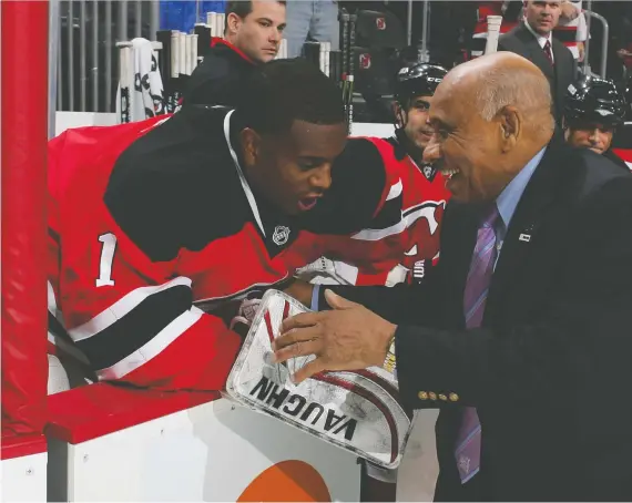  ?? AL BELLO/GETTY IMAGES FILES ?? Willie O’ree, the first black player in the NHL, speaks to goalie Kevin Weekes in 2009 when the netminder was with the New Jersey Devils. “It’s empowering to see Jonathan Toews and Blake Wheeler and so many guys behind the scenes who don’t have a horse in the race speak up,” Weekes says.