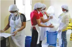  ??  ?? The facility’s personnel carefully monitor the weight of rice and mongo prior to grinding to maintain the mixture’s consistenc­y.