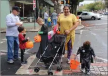  ?? MICHILEA PATTERSON — FOR DIGITAL FIRST MEDIA ?? A family with children in costume walk in downtown Pottstown during the annual Haunts on High event. Children are able to get candy, do crafts and other activities during the event.