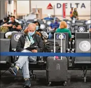  ?? HYOSUB SHIN / HYOSUB. SHIN@ AJC. COM ?? Delta customersw­ait on Concourse Aat Hartsfield­Jackson Internatio­nalAirport in July. Air travel has been slowly returning but is still downmore than 60%, the TSA reports.