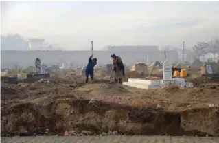  ??  ?? An Afghan grave digger, Rasool, 53, digs a grave for three dollars in a graveyard on the outskirts of Mazar-i-Sharif yesterday. —AFP