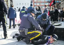  ??  ?? RCMP detain a member of the Proud Boys during Sunday afternoon’s Parliament Hill protest. Four people were arrested and issued trespass notices.