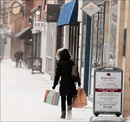  ?? Jeff Kowalsky / AFP / Tribune News Service ?? “Elevated prices, eroded personal savings and increased reliance on credit point to weak consumer spending this winter,” a senior economist at EY Parthenon says.