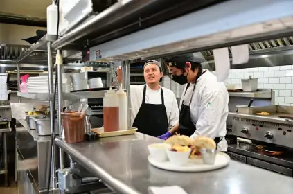  ?? ?? Aditya Khrisna, left, and Reza Prahadiva prepare lunches on March 29 at Mawa’s Kitchen.