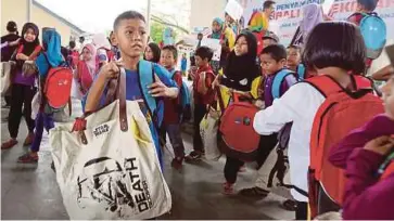  ??  ?? PELAJAR menerima bantuan beg sekolah di Dewan PPD Seberang Perai Tengah, Bukit Mertajam.