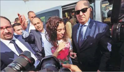  ?? MOHAMMAD ABU GHOSH / XINHUA ?? Jordanian Heba al-Labadi (middle) arrives at the King Hussein Bridge border crossing in Jordan on Wednesday after being released from custody in Israel. Labadi and another Jordanian detainee, Abdul Rahman Miri, were sent back in a move aimed at easing a standoff that has soured relations between the neighbors. The two had been detained for more than two months without charge. Their release comes as Israel and Jordan mark a chilly 25th anniversar­y of their historic peace deal. Labadi and Miri were arrested in August and September, respective­ly, after entering the West Bank to visit relatives.