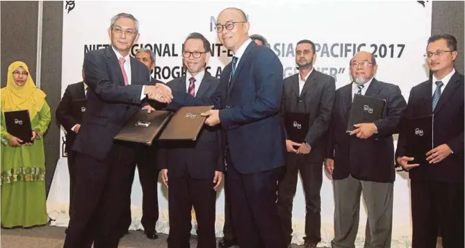 ??  ?? UNIRAZAK president and vice-chancellor Datuk Seri Dr Md Zabid Abdul Rashid (front, left) exchanging documents with Islamic Banking and Finance Institute of Malaysia chief executive officer Yusry Yusoff (front, right) during the signing of the memoranda...