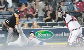  ?? John Bazemore Associated Press ?? ADRIAN GONZALEZ slides by umpire John Hirschbeck after being tagged out by A. J. Pierzynski while trying to score on an eighth- inning hit by Scott Van Slyke.