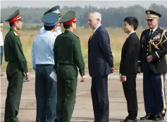  ?? — AFP photo ?? Mattis (third right) talks to Vietnamese military officials as he visits Bien Hoa airbase.