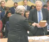  ?? HOUSE OF COMMONS ?? Former British Prime Minister Boris Johnson, right, takes an oath Wednesday before providing evidence at a parliament­ary hearing in London.