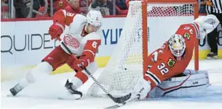  ?? ?? Blackhawks goaltender Alex Stalock denies Red Wings defenseman Ben Chiarot in overtime Friday.