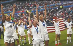  ?? The Associated Press ?? WORLD CHAMPIONS: United States’ Megan Rapinoe, center, holds the trophy as she celebrates with teammates Sunday after they defeated the Netherland­s 2-0 in the Women’s World Cup final at the Stade de Lyon in Decines, outside Lyon, France.