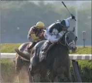  ?? PETER MORGAN — THE ASSOCIATED PRESS ?? Jose Ortiz raises his crop as he approaches the finish line riding Tapwrit to win the 149th running of the Belmont Stakes horse race, Saturday in Elmont, N.Y. Irish War Cry, ridden by Rajiv Maragh, left, finished second.