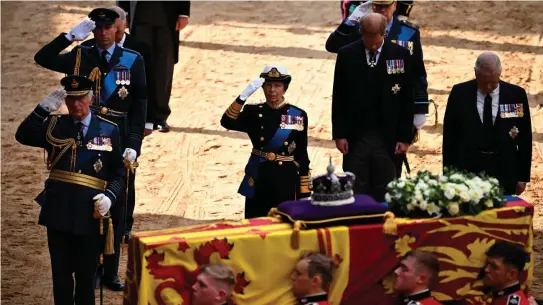  ?? BEN STANSALL / POOL / AFP ?? Britain’s King Charles III, Britain’s Prince William, Prince of Wales and Britain’s Princess Anne, Princess Royal salute, alongside Britain’s Prince William, Prince of Wales and Britain’s Prince Andrew, Duke of York as the coffin of Queen Elizabeth II, adorned with a Royal Standard and the Imperial State Crown, arrives at the Palace of Westminste­r, following a procession from Buckingham Palace, in London on September 14, 2022.