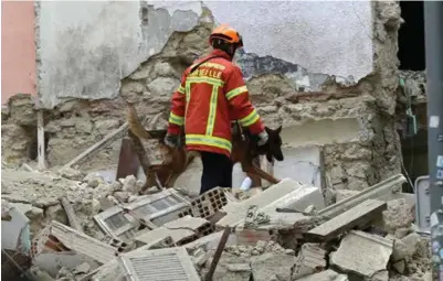  ?? CLAUDE PARIS ?? En brannmann og en spesialtre­nt hund søker gjennom ruinhaugen i Marseille etter flere ofre.
