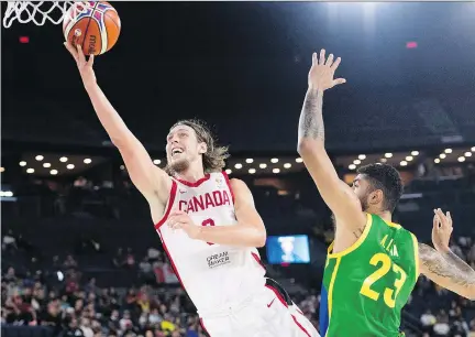  ?? GRAHAM HUGHES/THE CANADIAN PRESS ?? Canada’s Kelly Olynyk goes to the rim as Brazil’s Augusto Lima tries to defend during the third quarter of their FIBA Basketball World Cup qualifying match at Place Bell Thursday night. Canada won 85-77 to improve to 6-1 in Group F.