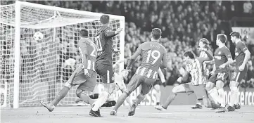  ??  ?? Chelsea’s Belgian midfielder Eden Hazard (left) shoots goalward and Atletico Madrid’s Montenegri­n defender Stefan Savic (right) blocks to score an own goal during a UEFA Champions League Group C football match at Stamford Bridge in London. — AFP photo