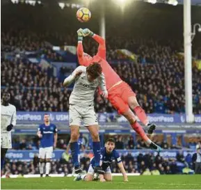  ?? AFP PIC ?? Everton’s goalkeeper Jordan Pickford (right) makes a save under pressure from Chelsea’s Marcos Alonso in a Premier League match at Goodison Park yesterday.