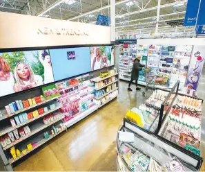  ?? (AP Photo/Eduardo Munoz Alvarez) ?? A shopper passes items inside the Walmart Supercente­r in North Bergen, N.J. Americans have continued to shop this year, shrugging off higher interest rates and prices.