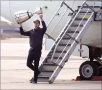  ?? CHRIS YOUNG, THE CANADIAN PRESS ?? Ricky Ray steps off a plane holding the Grey Cup as the Argonauts returned home Monday.