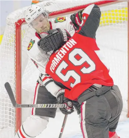  ?? SEAN KILPATRICK/AP ?? Hawks defenseman Duncan Keith gets a paw around the head of Senators winger Alex Formenton in the season opener.