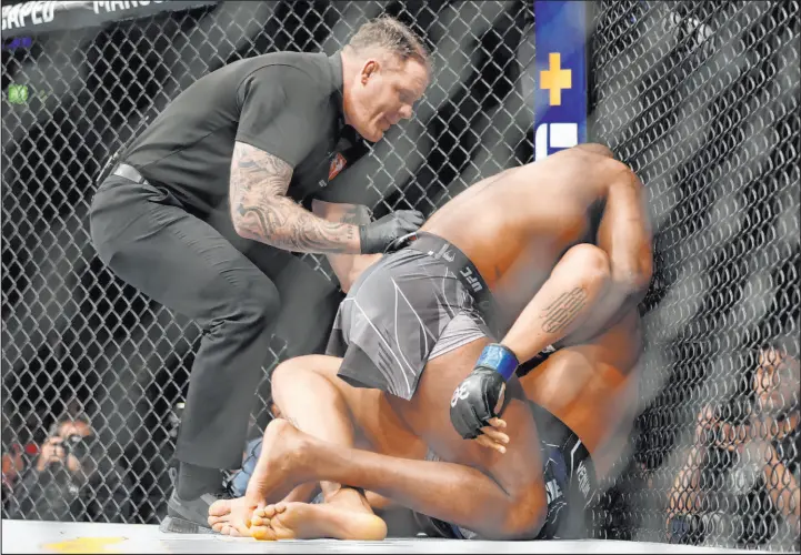  ?? Erik Verduzco
Las Vegas Review-journal ?? Jon Jones, left, chokes Ciryl Gane into submission at 2:04 of the first round of their heavyweigh­t title bout Saturday night at T-mobile Arena.