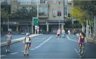  ?? (Miriam Alster/Flash90) ?? CHILDREN RIDE bikes and scooters along a Tel Aviv street on Yom Kippur as Israel comes to a virtual 25-hour standstill for the holiest day of the Jewish year.