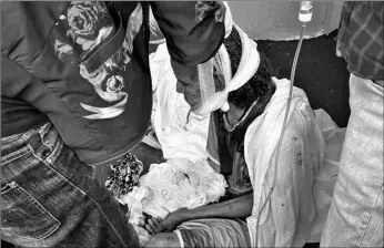  ?? AP Photo ?? An elderly woman who fled to the city of Axum in the Tigray region of Ethiopia to seek safety sits with her head bandaged after being wounded during an attack on the city, in 2020.