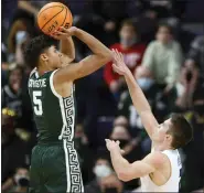  ?? PAUL BEATY — THE ASSOCIATED PRESS ?? Michigan State’s Max Christie, left, goes up for a shot against Northweste­rn’s Ryan Greer in MSU’S win Sunday.