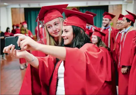  ?? SARAH GORDON/THE DAY ?? Friends Bridget Feeley, left, and Adelaide Horgan take a selfie during Saint Bernard School’s Commenceme­nt on Friday at the Cathedral of Saint Patrick in Norwich. Visit theday.com to view a photo gallery and read a full list of graduates.