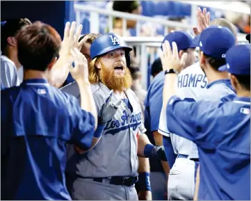  ?? AP PHOTO BY WILFREDO LEE ?? Los Angeles Dodgers’ Justin Turner, center, celebrates with teammates after hitting a home run during the first inning of a baseball game against the Miami Marlins, Sunday, in Miami.