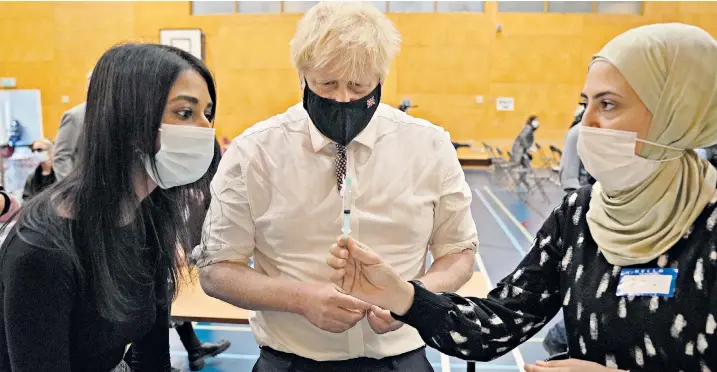  ?? ?? Prime Minister Boris Johnson visits a Covid-19 vaccinatio­n centre at Little Venice Sports Centre in London