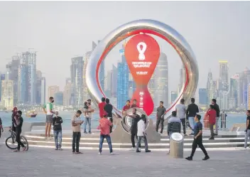  ?? AP ?? People gather around the official countdown clock showing the remaining time until the kick-off of World Cup 2022 in Doha, Qatar..