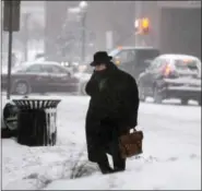  ?? MICHAEL GREENLAR — THE SYRACUSE NEWSPAPERS VIA AP ?? A man crosses E. Washington St. in downtown Syracuse, N.Y. Friday.