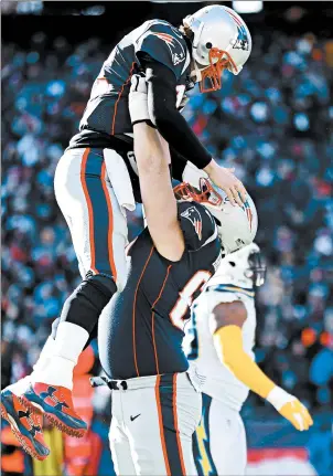  ?? MADDIE MEYER/GETTY IMAGES ?? Tom Brady, left, reacts with David Andrews after a touchdown during the first quarter in the AFC Divisional Playoff Game against the Los Angeles Chargers at Gillette Stadium on Sunday.