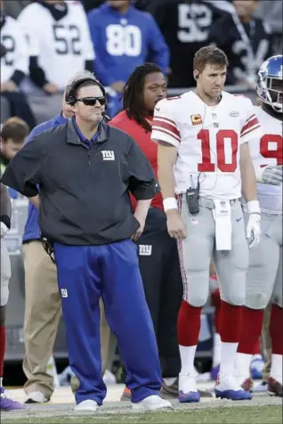  ?? MARCIO JOSE SANCHEZ — THE ASSOCIATED PRESS ?? New York Giants head coach Ben McAdoo, left, stands next to quarterbac­k Eli Manning (10) during the second half of an NFL football game against the Oakland Raiders in Oakland Sunday.