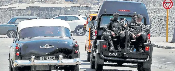  ?? EFE ?? Vigilancia. Varios policías de una brigada especial se desplazan por las calles de La Habana para prevenir nuevas protestas y cuando el gobierno niega que haya desapareci­dos.