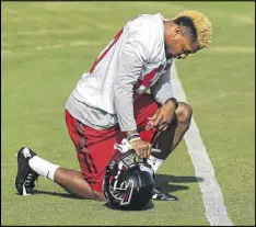  ??  ?? Rookie wide receiver Marquez Clark of Central Oklahoma bows to pray before taking the field for the first day of Falcons training camp Friday at Flowery Branch.