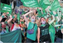  ?? Photo / AP ?? Argentinia­n abortion rights activists watch live video as the Government passes a law legalising abortion on December 30.