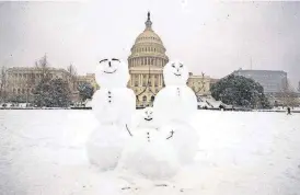  ?? [AP PHOTO] ?? A snow family is seen on Capitol Hill as a winter storm arrives in the region, Sunday in Washington.