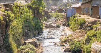  ?? A TRIBUTARY Khalil Senosi Associated Press ?? of the Nairobi River, f looded with garbage, f lows through an informal settlement. Most slum residents cannot afford toilets. Meanwhile, factories are accused of dumping pollutants into the water.