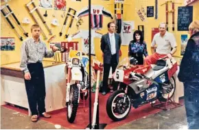  ??  ?? Stuart (centre, in suit and tie) on the WP stand at the London Motorcycle Show at Earls Court. The early Norton rotary is on display because Stuart supplied the fledgling team with suspension