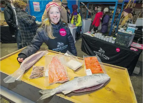 ?? RIC ERNST/PNG ?? Sonia Strobel displays frozen tuna, salmon and cod that is available through Skipper Otto’s community-supported program.