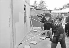  ??  ?? Several members of the convoy paint one of the houses in Kampung Jabai, prior to flag-off.