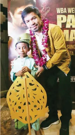  ?? Promotions) (MP ?? SEN. MANNY Pacquiao poses with a young well-wisher.