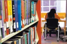  ?? Michael Rubinkam ?? The Associated Press Dierra Rowland, 19, of Philadelph­ia, studies at the Indiana University of Pennsylvan­ia library in Indiana, Pa., near a shelf of books marked with red stickers, meaning they might be removed from the shelves.